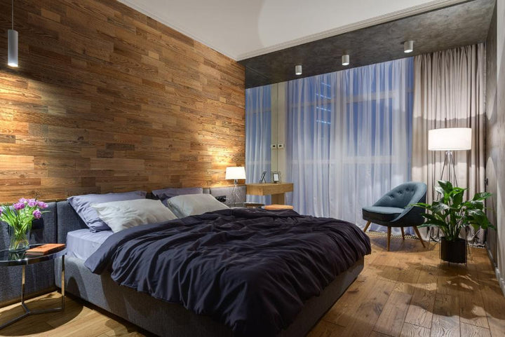 Interior bedroom featuring Amber Weathered Plank Wood Wall Panels installed on the walls behind a cosy bed