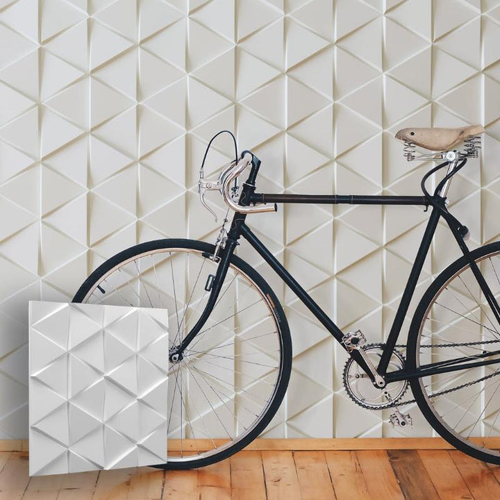 Hallway wall featuring triangular design clover plaster panels, behind a vintage bicycle