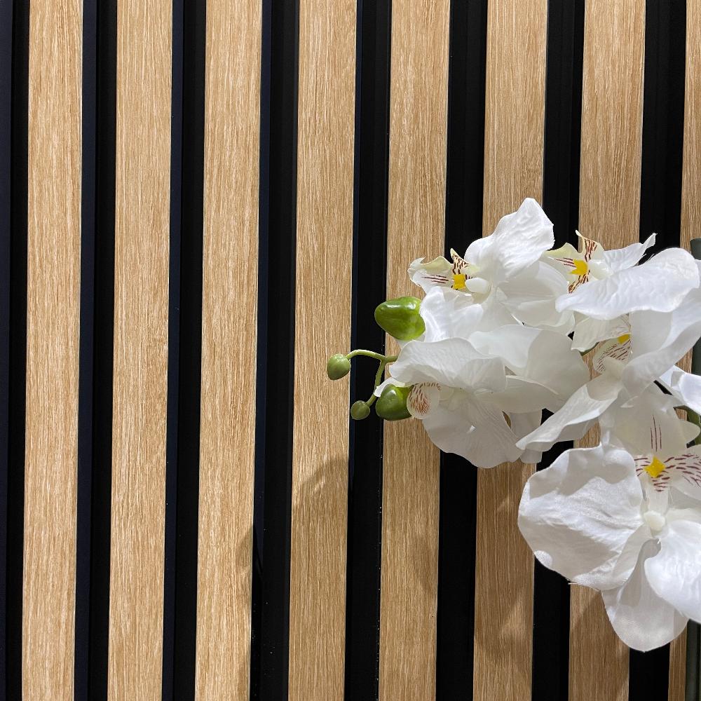 American Beech Slat Wall Eco Panel as a backdrop for a vase with white flowers