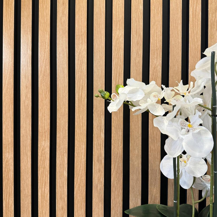 White flowers in a vase against the textured backdrop of American Beech Slat Wall Eco Panels