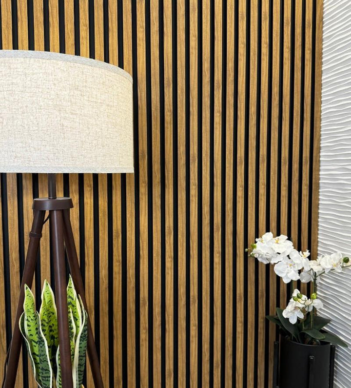 Stylish table lamp on a surface with English Oak Slat Wall Eco Panels and a green plant beside it