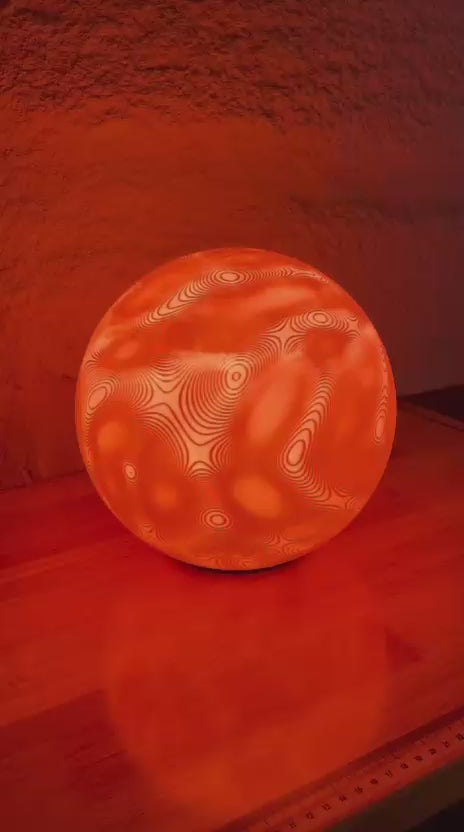 video of textured sphere lamp with a changing colour bulb inside 