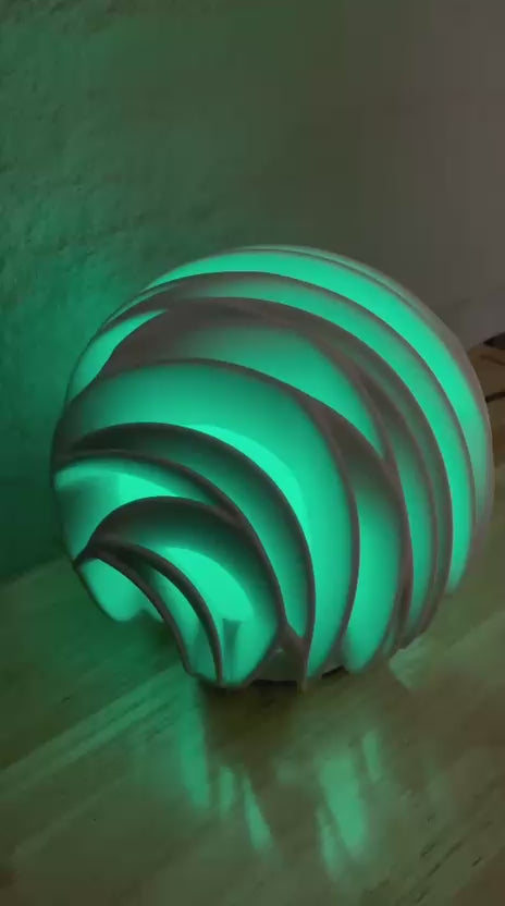 video of multi colour changing sculptural lamp  on a coffee table